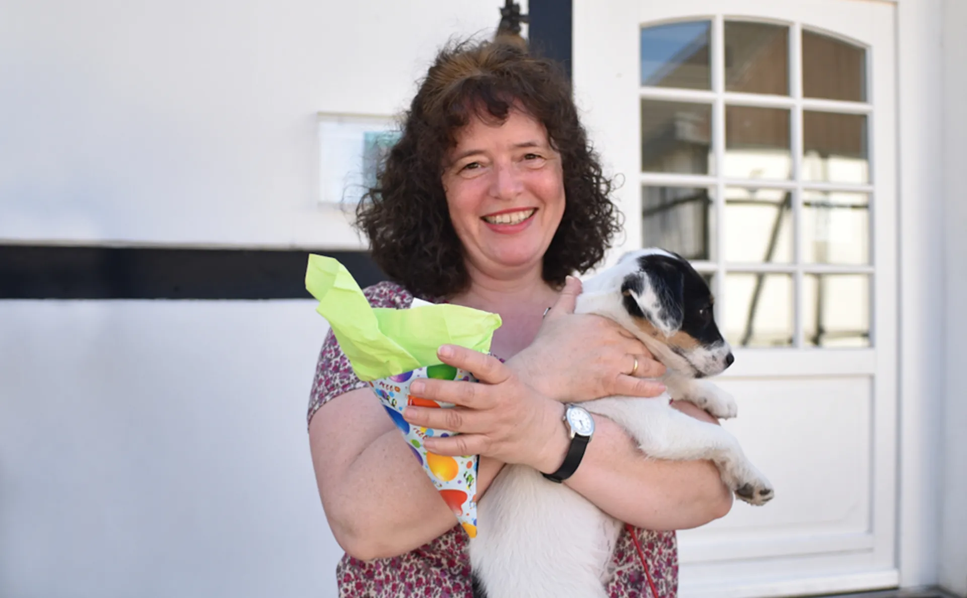 Eine Frau freut sich über einen Preis der Hundeschule